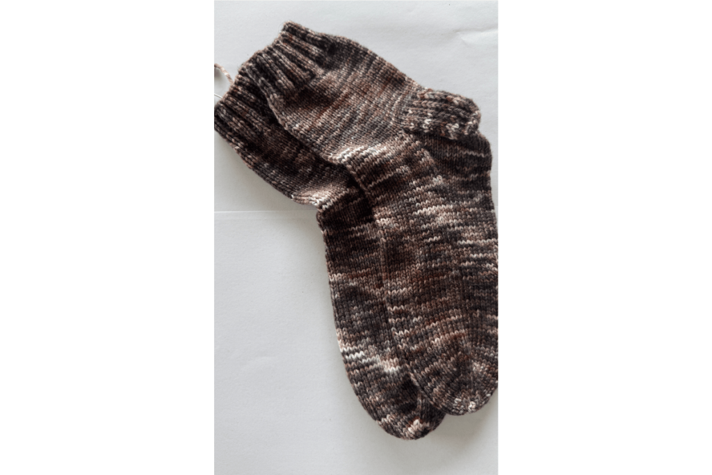 Pair of hand-knit DK socks in rich brown tones, lying flat on a white background.